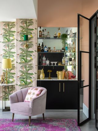 living room with bar area and bright wallpaper, lilac armchair and orange walls