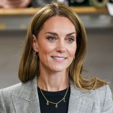 Kate Middleton wearing a gray suit and smiling