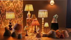 GP&J Baker x Pooky Lighting collection, which includes various archival-patterned lamps, photographed in a large, wallpapered space.