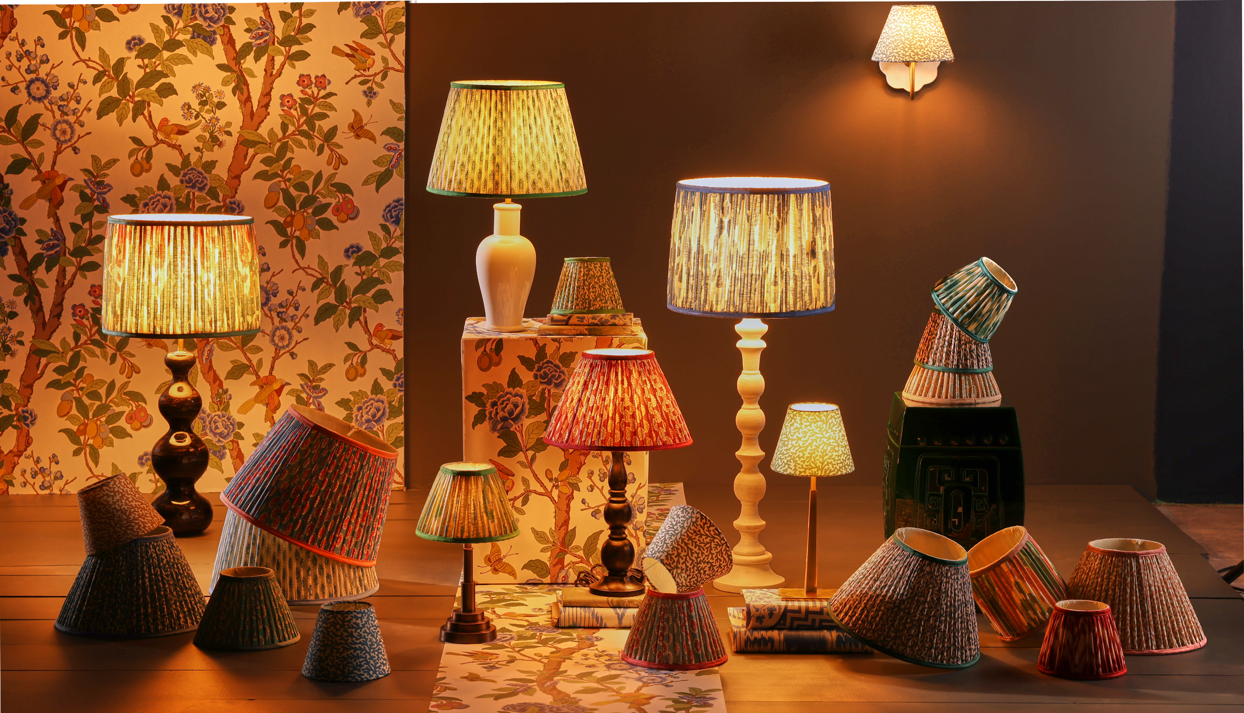 GP&J Baker x Pooky Lighting collection, which includes various archival-patterned lamps, photographed in a large, wallpapered space.