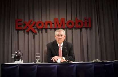 Rex Tillerson sits beneath an ExxonMobil sign
