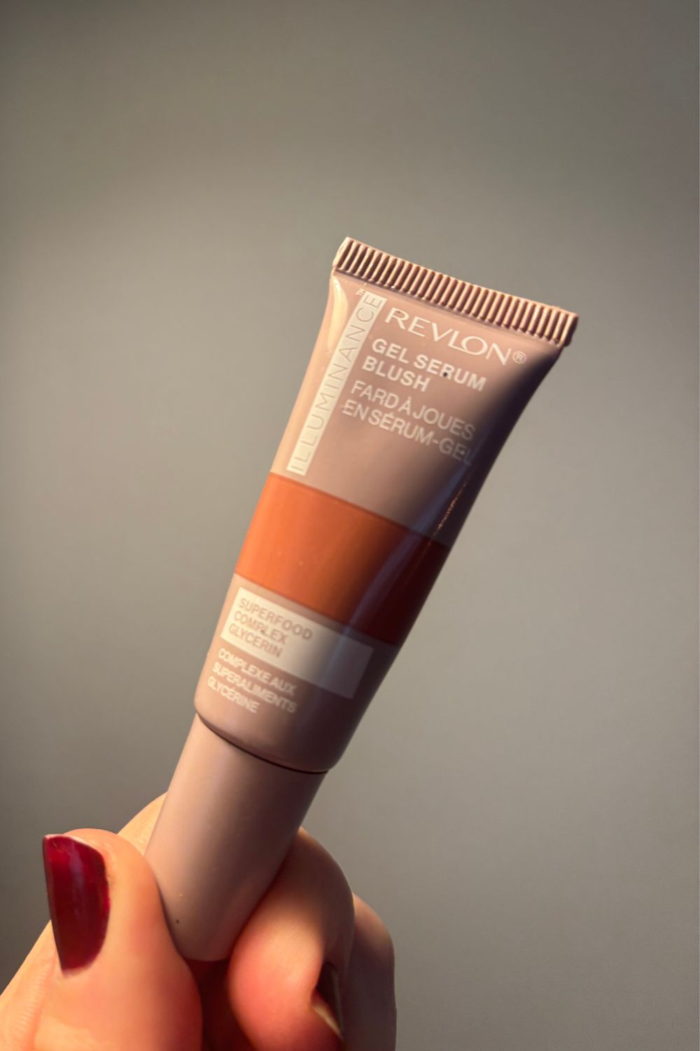 una mano sosteniendo el colorete revlon Illuminance