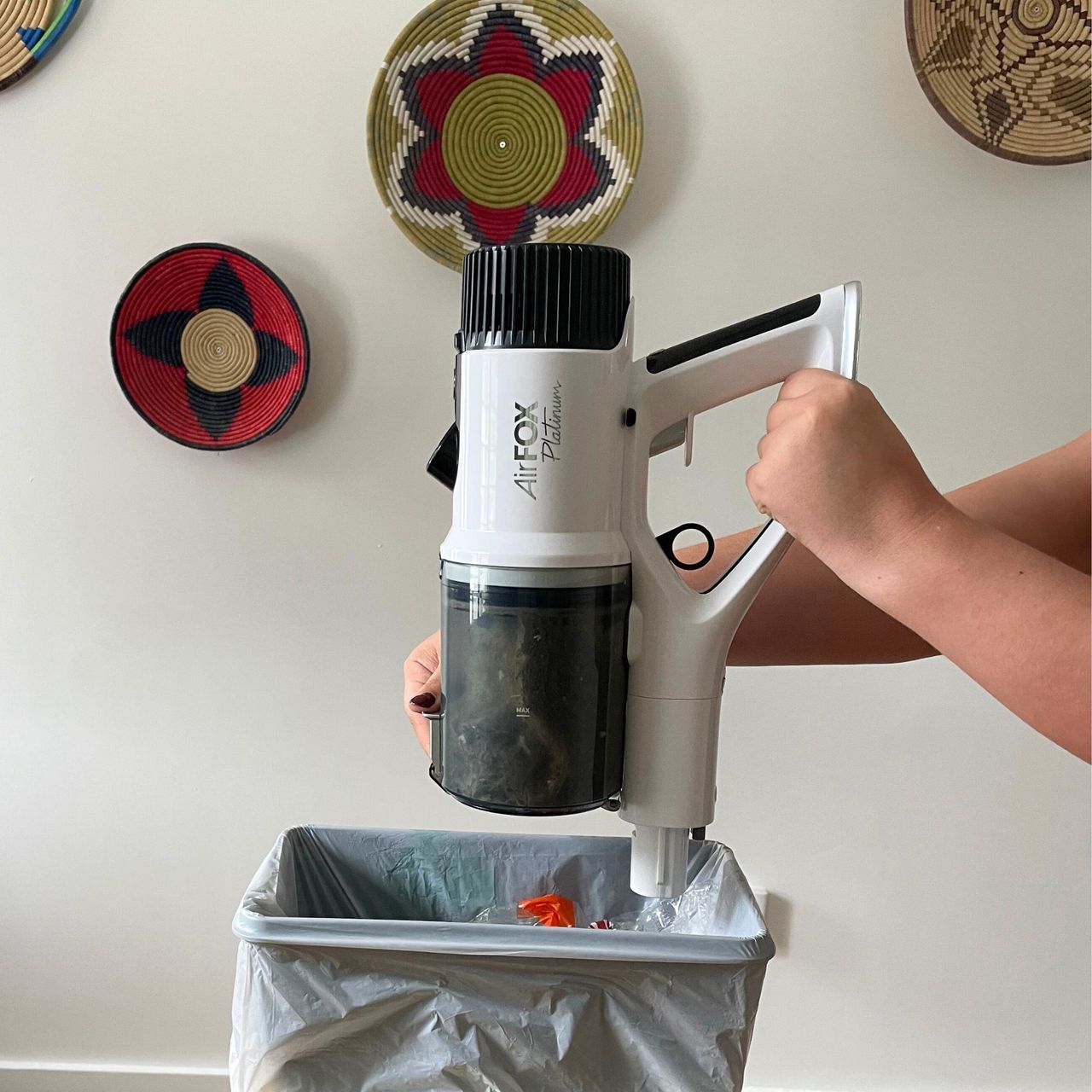 emptying the Gtech AirFOX Platinum Cordless Vacuum over a bin