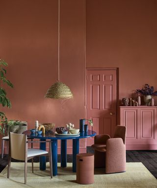 blue dining table in terracotta painted room