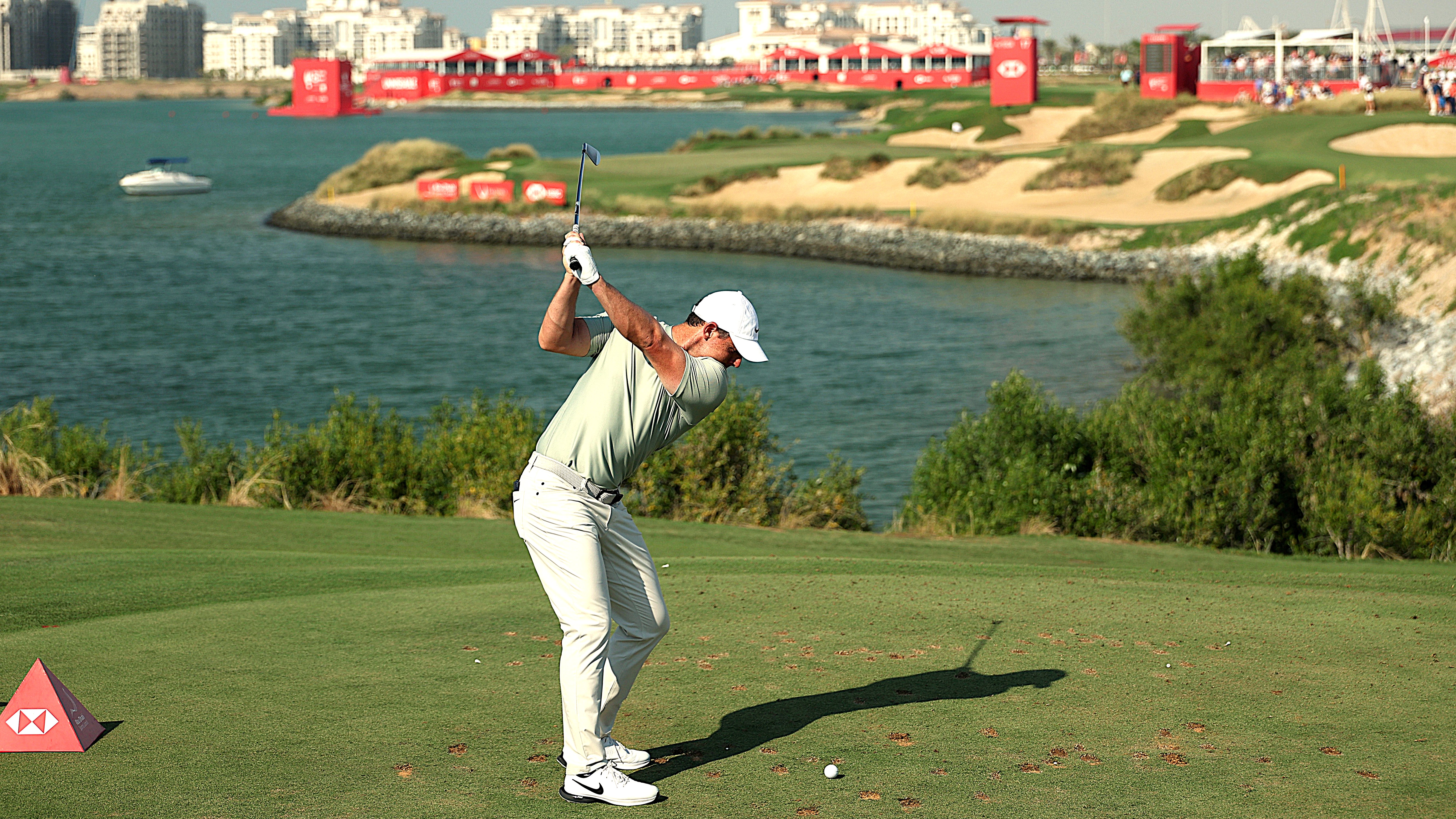 Rory McIlroy on the tee playing the par-3 17th hole which requires a tee shot over the Arabian Gulf to an elevated green