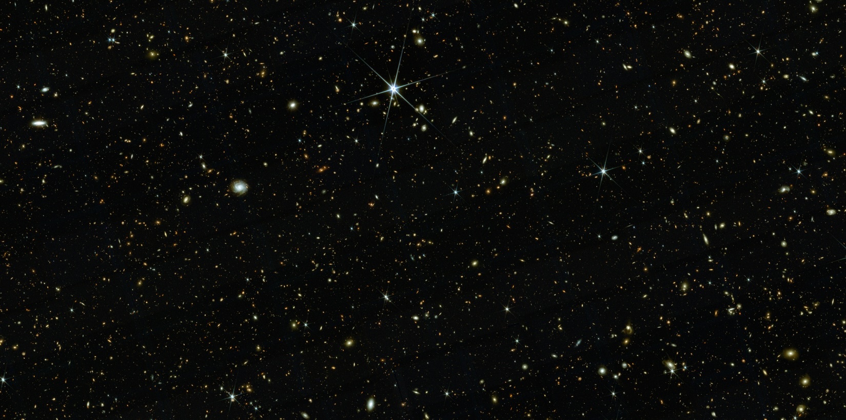 an image of outer space showing many small, sparkling galaxies