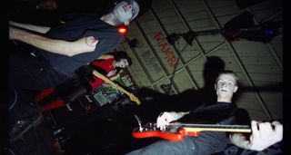 Ink & Dagger perform in makeup in a suitably punk looking venue with spray-painted walls.