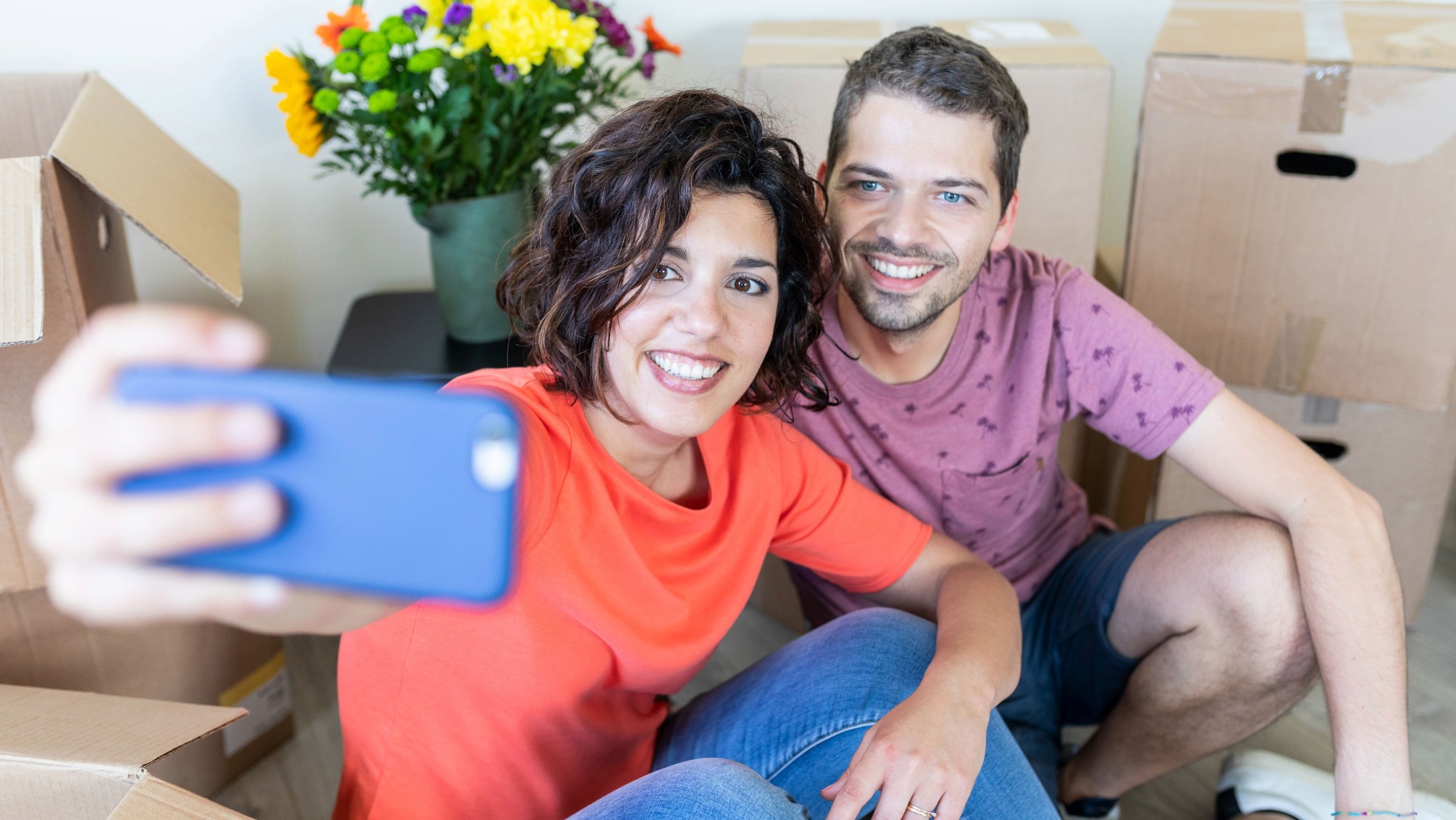 Happy couple taking a selfie in new home