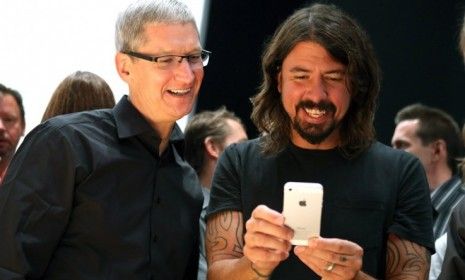 Apple CEO Tim Cook and Dave Grohl of the Foo Fighters play with the new iPhone 5 on Sept. 12: Some analysts believe Apple will sell roughly 12 million new iPhones by month&amp;#039;s end.