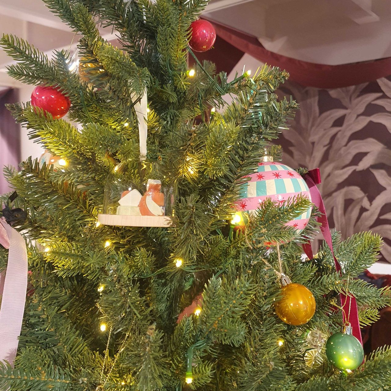 A Christmas tree decorated with Next baubles, including a selection of cheeses under a glass dome, taken at the brand's Christmas 2026 press show