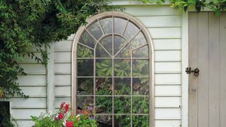 large arched mirror in garden