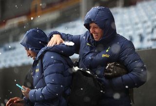 Tottenham's Pierluigi Gollini, right, and Emerson Royal play in the snow as the match at Burnley is postponed