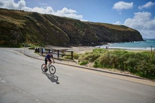 A cyclist riding next to the Welsh coast