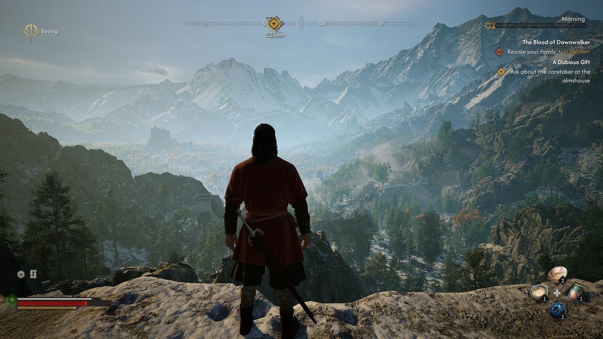A man stands at a cliff edge looking into the distance