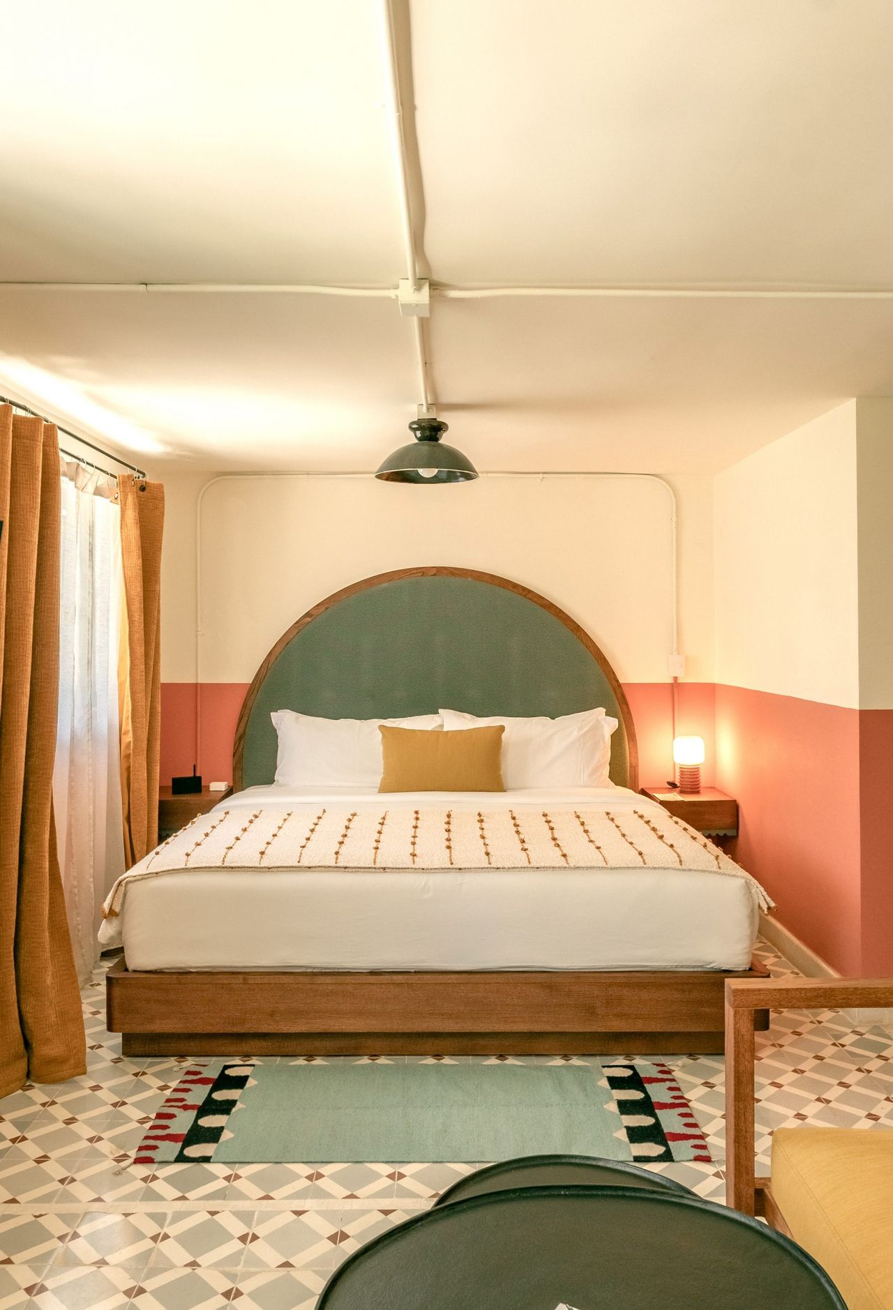 A vibrantly decorated hotel featuring a pastel palette of pinks, greens, and browns, tiled surfaces, and a vaguely Art Deco, contemporary feel.
