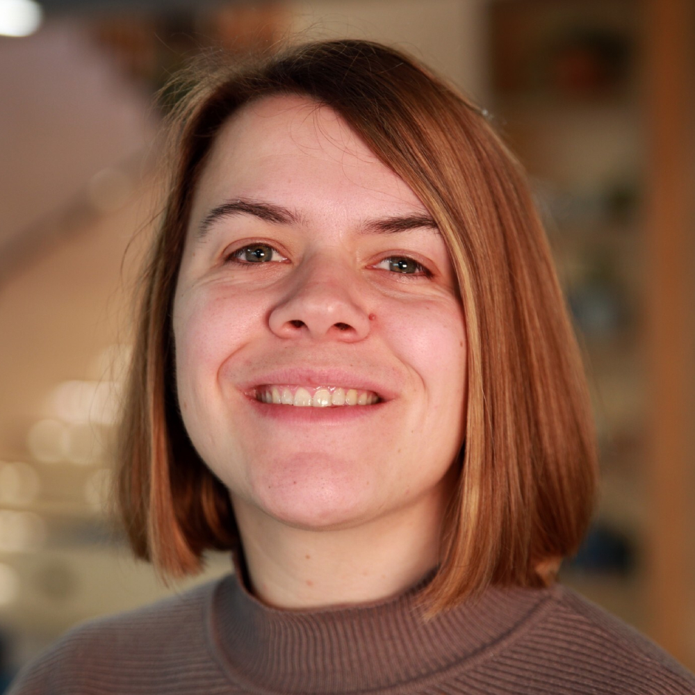 woman with auburn mid length hair smiling at camera