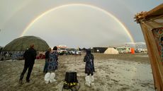 Attendees look at a double rainbow over flooding at Burning Man festival