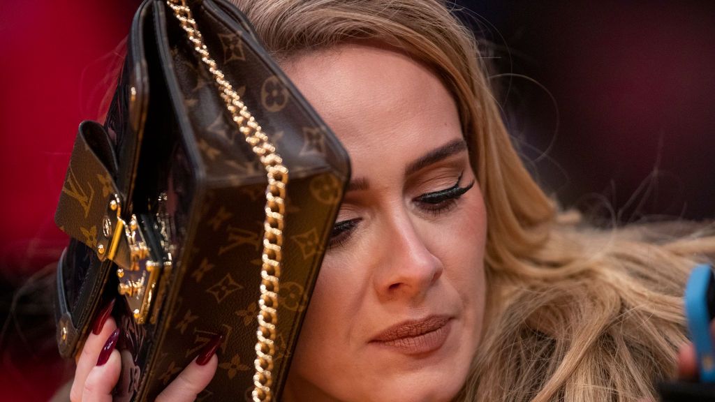 los angeles, ca october 19 singer adele uses her purse to hide from the tv camera while she sings along to her song being played to the audience while attending a game between the golden state warriors and the los angeles lakers on october 19, 2021 at staples center in los angeles allen j schaben los angeles times via getty images