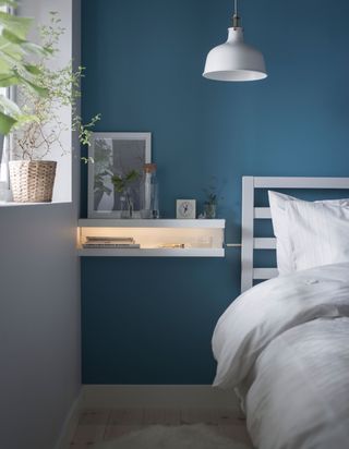 bedside table made from two picture ledges with blue walls and white bedding