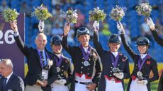 The British team of Fiona Bigwood, Becky Moody, Carl Hester and Lottie Fry stand on the podium with their silver medals at the 2026 FEI Dressage World Championship at Aachen