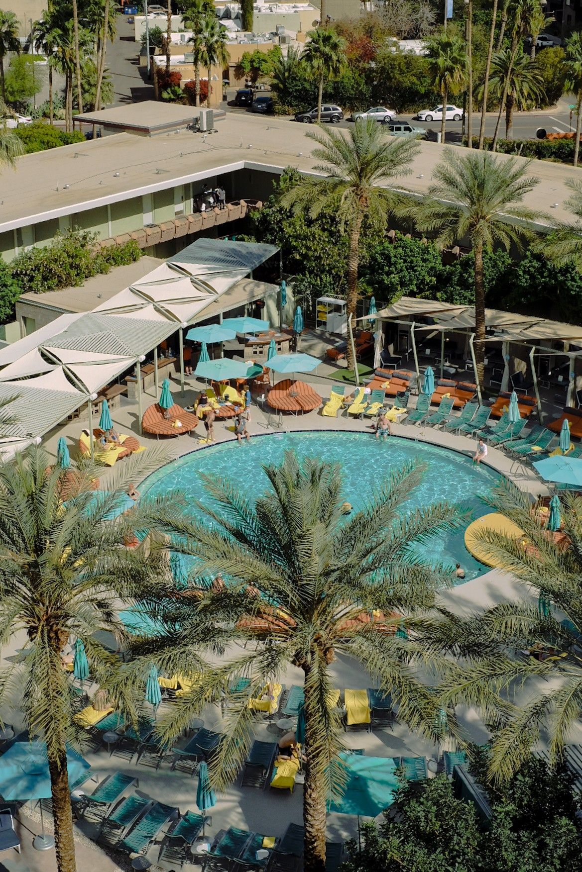 A series of photos showcasing a mid-century modern hotel with linear architecture, palm trees-filled exterior, and beautiful mountain views.