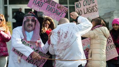 Protesters simulating a flogging scene in front of the Saudi Embassy in Washington DC