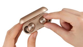 Technics EAH-AZ40M2 earbuds and case in rose gold, held in a hand