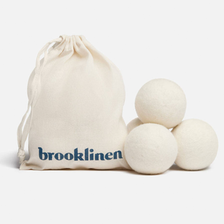 A pack of 3 wool dryer balls with a natural canvas Brooklinen bag