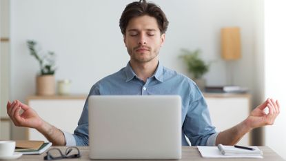 Man at laptop meditating