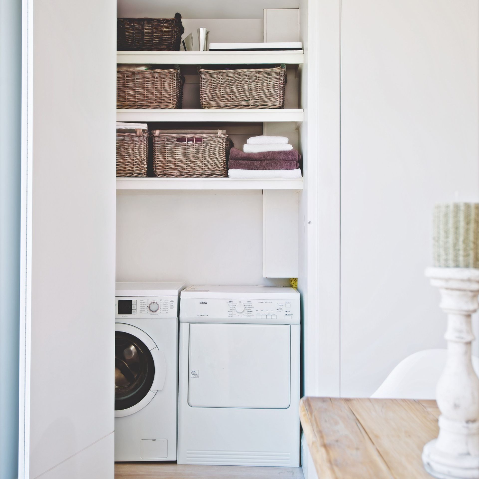 washing machine and dryer in laundry room with storage
