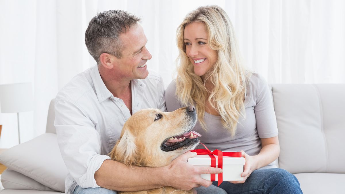 Man giving lady one of of the best gifts for dog owners while dog watches