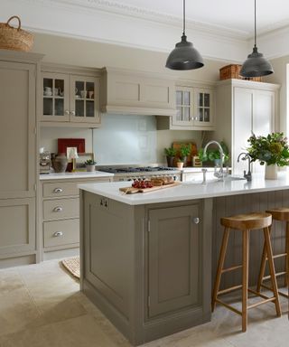 Grey painted shaker style kitchen with island and wooden bar stool