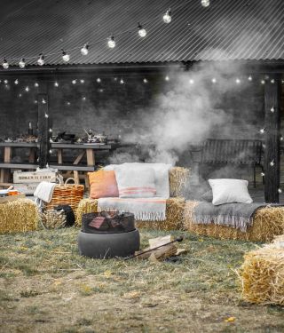 Fire pit surrounded by hay bales for a campfire themed night