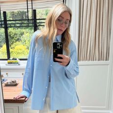 Gwyneth Paltrow wears a blue shirt and cream trousers.