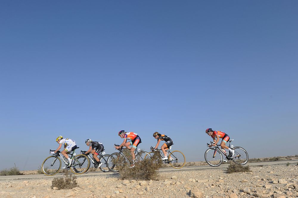 The field rides through desert roads at the Ladies Tour of Qatar
