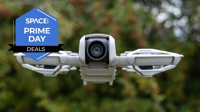 A DJI Neo drone flying against a blurred tree background.