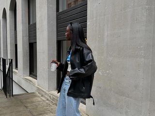 influencer wears white t-shirt with leather jacket, jeans and sneakers