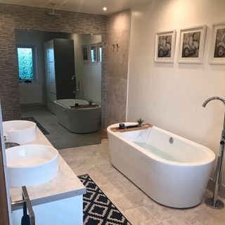 bathroom with bathtub wash basin and bright white walls mirror on wall faucet