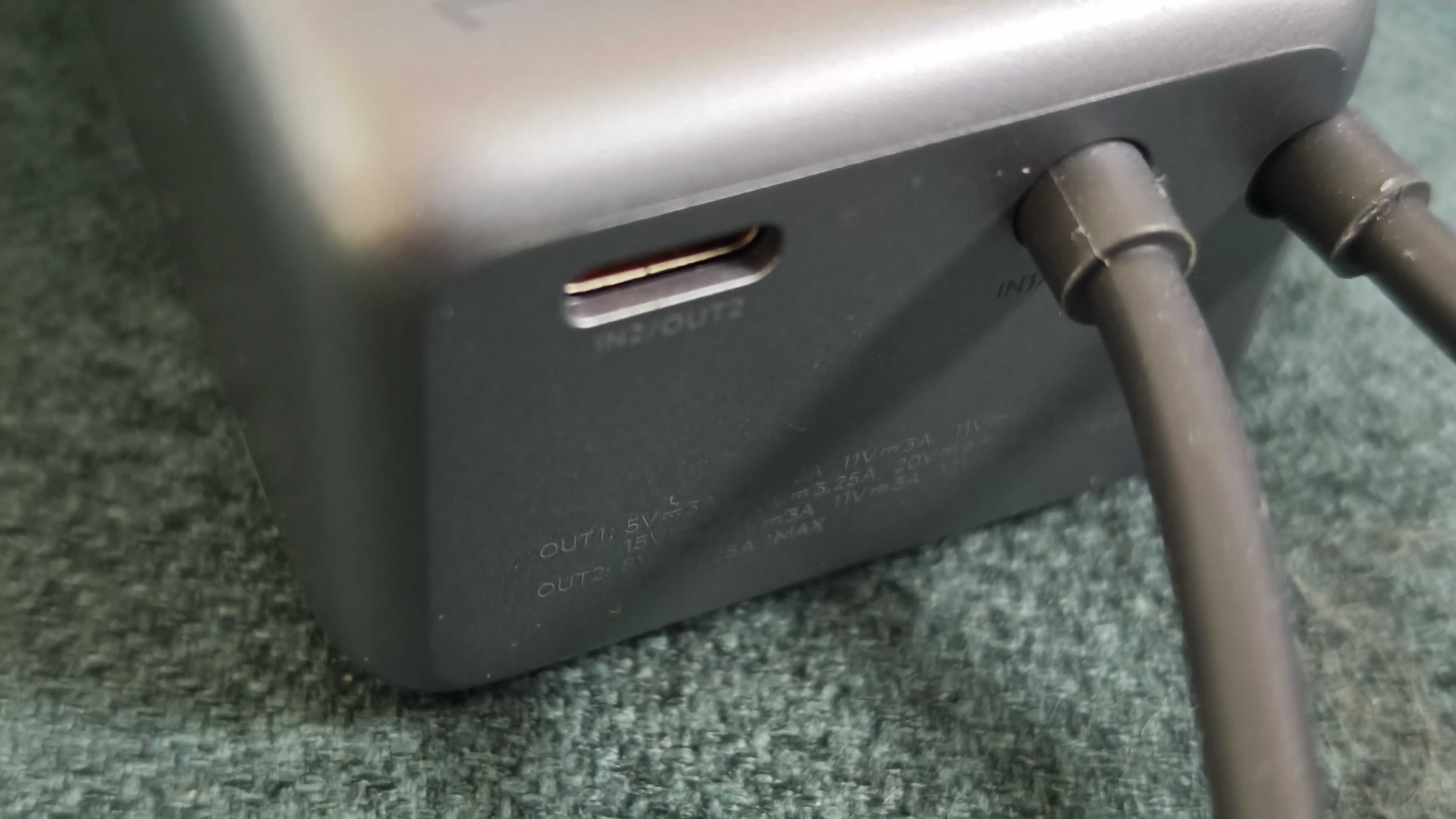 A matte grey Xiaomi 165W Power Bank on a green sofa