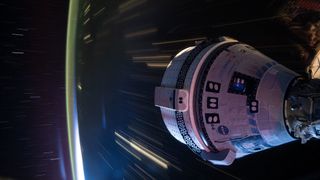 starliner spacecraft pictured docked to the Harmony module's forward port. This long-duration photograph was taken at night from the orbital complex as it soared 258 miles above western China.