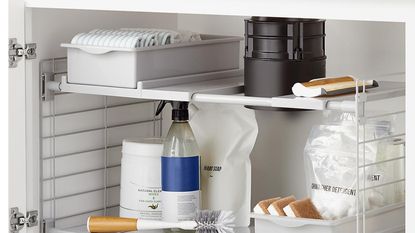Under the sink kitchen storage unit by The Container Store with toilet brush and baskets