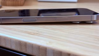 An iPhone 16 Pro on a wooden desk