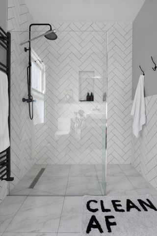 White chevron bathroom tile idea with walk in shower