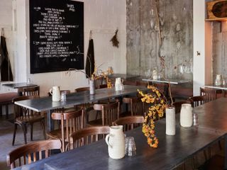 The brutalist interiors of Jolene manage to preserve the warmth and homeliness of its dishes through wood and flower accents.