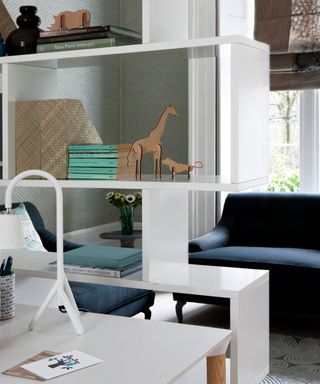 Living room detail with white freestanding shelving, wooden animal fig