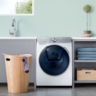 restroom with washing machine and wooden laundry basket
