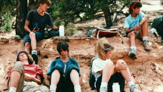 Teens sit on the ground in Hell Camp: Teen Nightmare