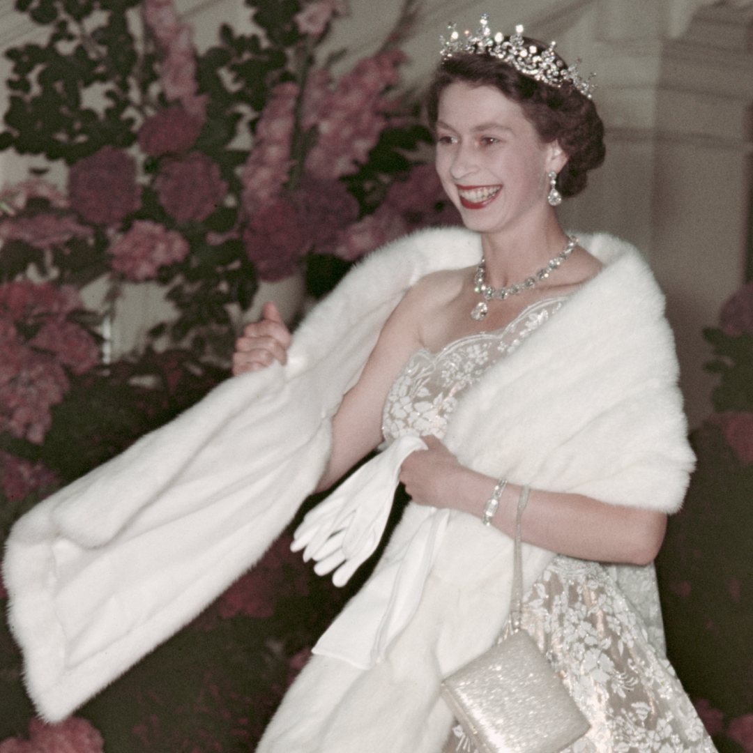 Queen Elizabeth wearing a stole and diamond tiara with a white gown