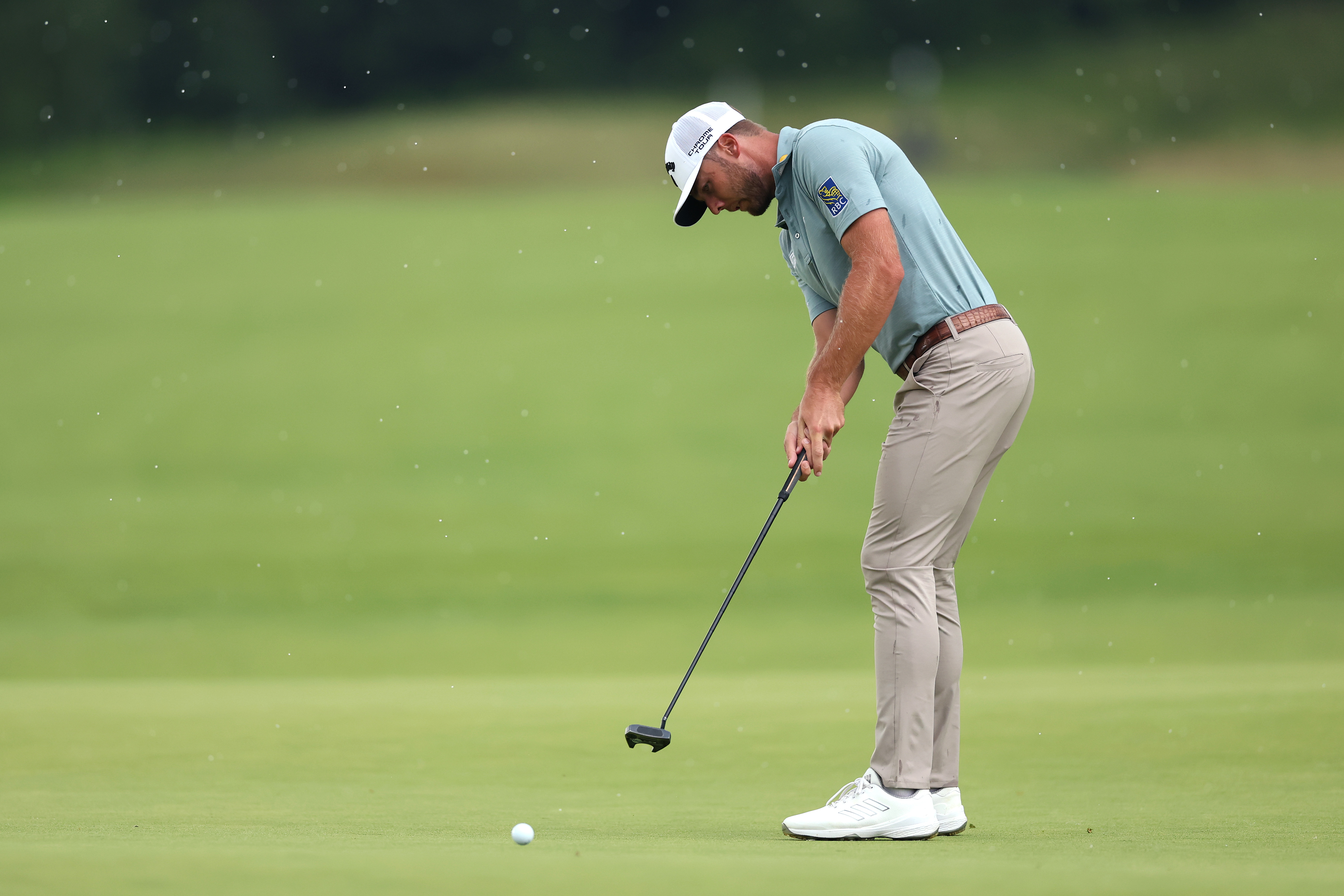 Sam Burns hits a putt on the green