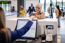 Woman receives passport back at airport counter